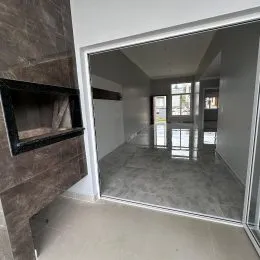 Foto de um corredor interno com paredes brancas e piso claro.