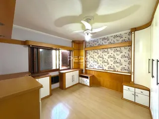 Sala de estar com piso de madeira e armários embutidos.