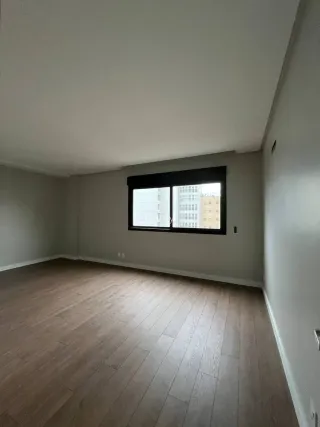 Foto de um cômodo com piso de madeira e uma janela grande.