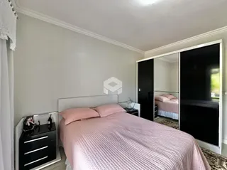 Quarto com cama e armário de espelho em um imóvel.
