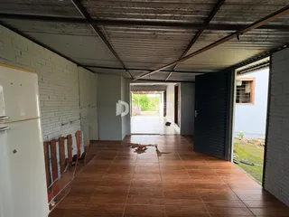 Imagem de uma área interna com piso de madeira e acesso ao exterior.