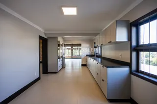 Hall de cozinha com armários e piso claro.