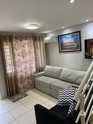 Sala de estar com sofá e cortinas em um imóvel no Brasil.