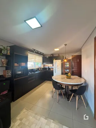 Uma sala de estar com mesa redonda e armários escuros.