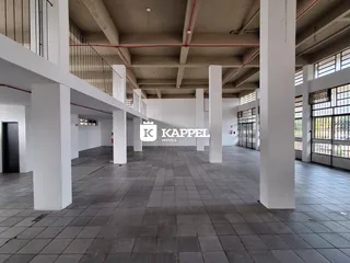 Foto de um hall amplo com colunas brancas e piso de cerâmica.