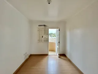 Interior de um ambiente com piso de madeira e paredes brancas.