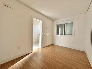 Ambiente interno com piso de madeira e paredes brancas.