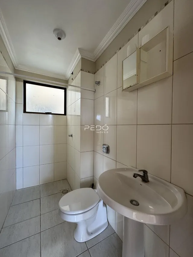 Foto de um banheiro com revestimento cerâmico nas paredes e piso.