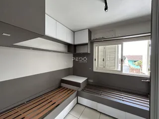Quarto moderno com cabeceira em madeira e armários embutidos.