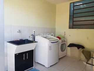 Foto de uma área de serviço com máquina de lavar e secar em um imóvel.