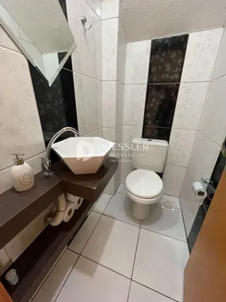 Foto de um banheiro com azulejos brancos e cinzas.