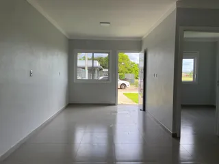 Hall de entrada com piso de cerâmica e portas de vidro que dão acesso ao exterior.