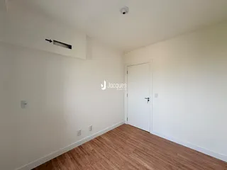 Ambiente interno com piso de madeira clara e paredes brancas.