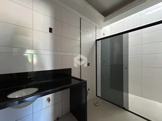 Foto de um banheiro com revestimento branco e box de vidro.