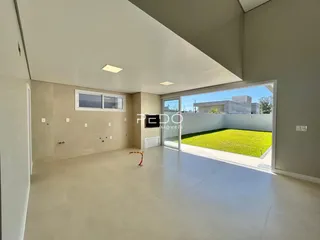 Sala de estar com grande abertura para o quintal gramado.