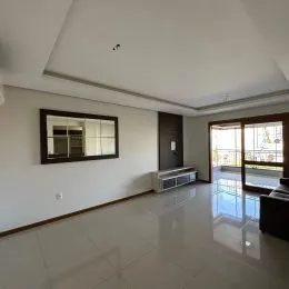 Foto de um corredor interno com piso claro e espelho na parede.