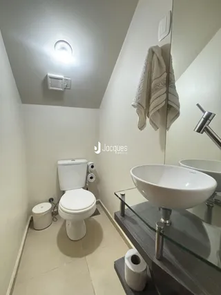 Foto de um banheiro moderno com louças brancas.