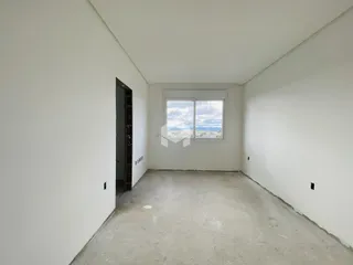 Vista interna de um cômodo vazio com piso de concreto.