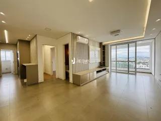 Ambiente interno de uma sala de estar com grandes janelas de vidro.
