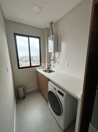 Vista interna de uma área de serviço com máquina de lavar roupa.
