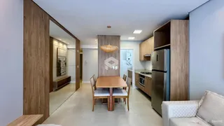 Interior de uma sala de jantar com painéis de madeira e piso claro.