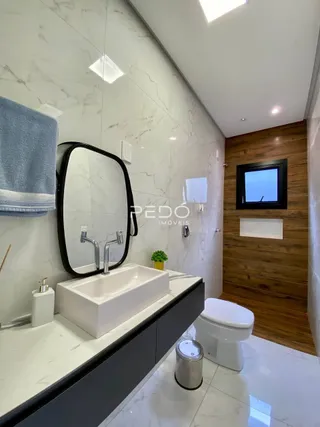 Foto de um banheiro moderno com pia e vaso sanitário.