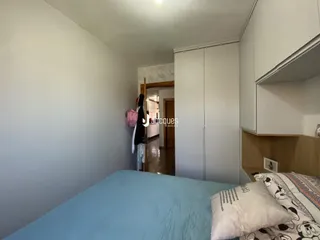 Quarto com armários embutidos e cama em um ambiente claro.