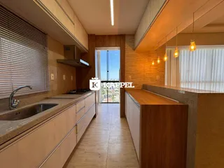 Cozinha com armários de madeira e bancada clara.