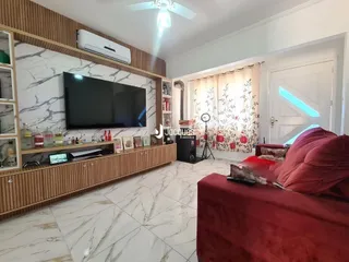 Uma sala de estar com sofá vermelho e painel de madeira.