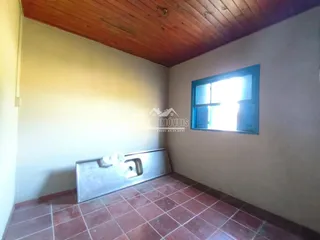 Vista interna de um corredor com piso de cerâmica e teto de madeira.