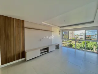 Sala de estar com piso claro e parede de madeira em um imóvel no Brasil.