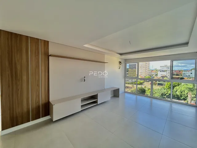 Sala de estar com piso claro e parede de madeira em um imóvel no Brasil.