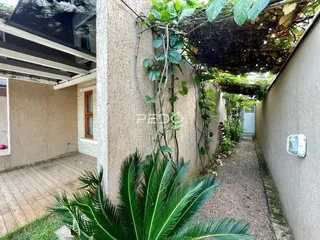 Fachada lateral de um imóvel em Lajeado, Brasil, mostrando um pátio estreito com vegetação.