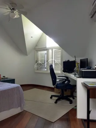 Foto de um quarto com teto inclinado e piso de madeira.