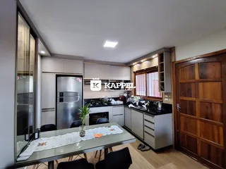 Uma foto de uma cozinha moderna com bancadas escuras e armários claros.