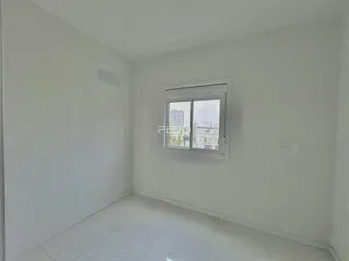 Ambiente interno de um cômodo com paredes brancas e piso de cerâmica.