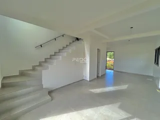 Hall de entrada com escadaria em ambiente interno.
