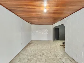 Hall de corredor com piso de cerâmica e teto de madeira.