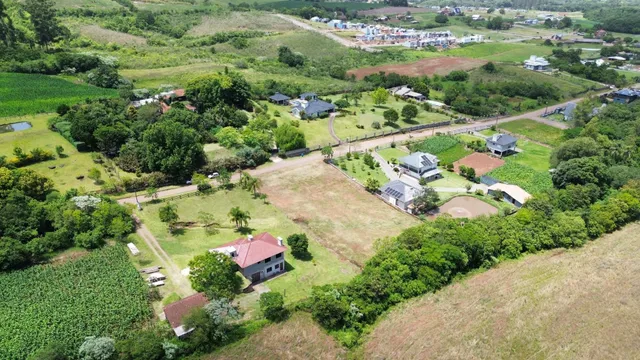 Vista aérea de uma propriedade rural com campos verdes ao redor.