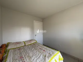 Quarto com cama e porta branca em uma residência.