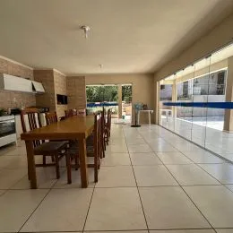 Sala de jantar com mesas de madeira e piso de cerâmica.