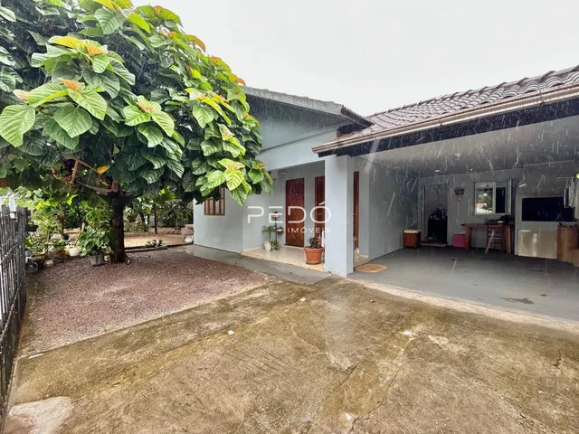 Fachada de uma casa em Lajeado, Brasil, com jardim e árvore na frente.