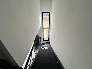 Vista de um corredor com escadaria em uma residência.