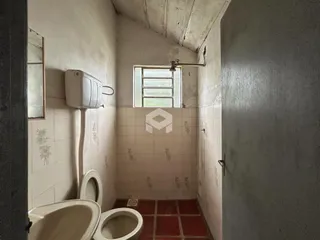 Um banheiro com azulejos brancos e piso vermelho.