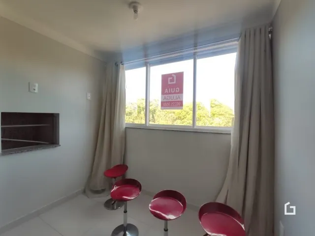 Quarto interno com janela e cortinas claras.