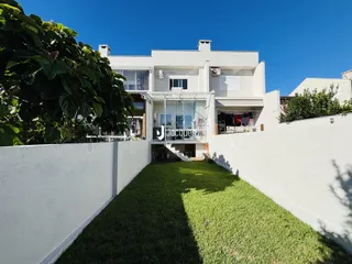 Fachada de uma casa branca com jardim gramado em Lajeado, Brasil.
