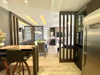 Ambiente interno de sala de jantar com piso de madeira e detalhes em madeira escura.