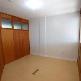 Sala de estar com paredes brancas e painéis de madeira.