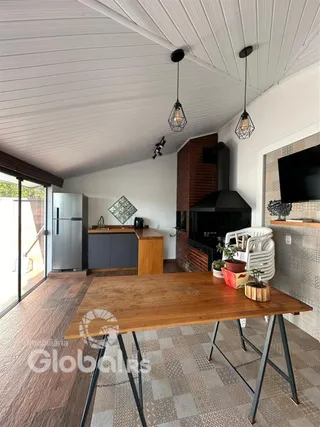 Sala de estar com piso de madeira e mesa de jantar em um imóvel.
