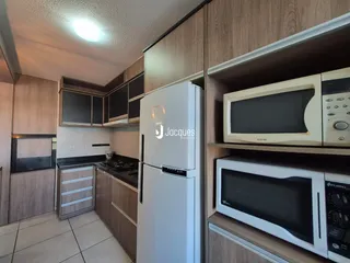 Interior da cozinha com armários de madeira e eletrodomésticos modernos.